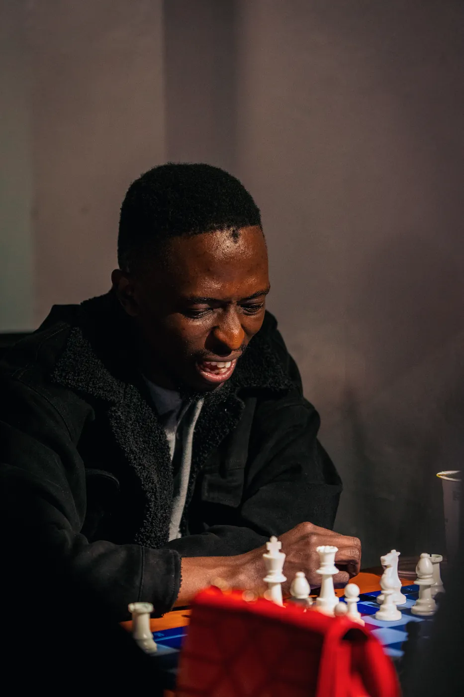 A player in a black sherpa jacket grins down at his position